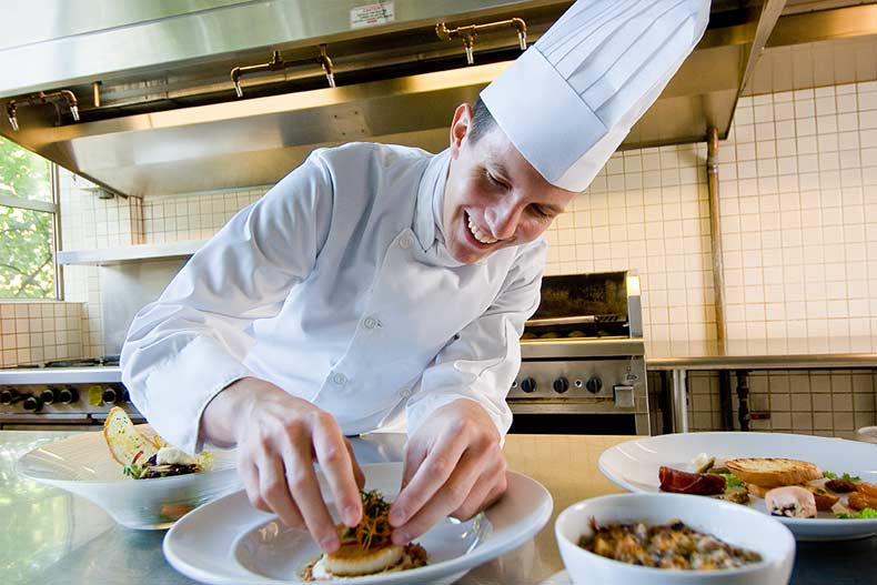 Chef plating food in a kitchen