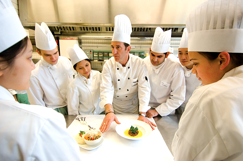 Head Chef with six chef students in a kitchen